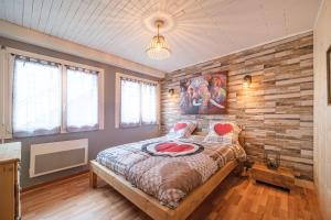 um quarto com uma parede em madeira e uma cama em Le Loft em Ornans