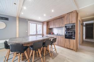 uma cozinha com uma grande mesa de madeira e cadeiras em Le Loft em Ornans