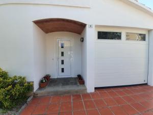 a white house with a white garage door at Holiday Home Villa Guapa in L'Estartit +30 photos