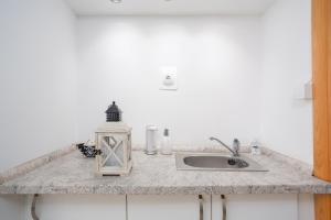 a kitchen counter with a sink and a candle at Apartment Tina in Vrh +6 photos