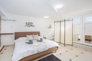 een witte slaapkamer met een bed met handdoeken erop bij Apartment Tina in Vrh