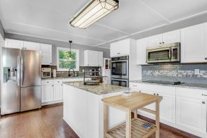 a kitchen with white cabinets and stainless steel appliances at Morning Mist Lake House in Lithonia