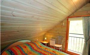 - une chambre dans une cabane en rondins avec un lit et une fenêtre dans l'établissement Chalet chaleureux à Basse-sur-le-Rupt, vue montagne superbe, à Basse-sur-le-Rupt