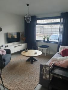 uma sala de estar com um sofá e uma mesa em Ruunerwoldse Stekkie met eigen badkamer em Ruinerwold