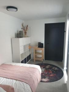 een slaapkamer met een bed en een zwarte deur bij Ruunerwoldse Stekkie met eigen badkamer in Ruinerwold