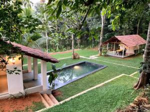 Un patio trasero con piscina y una casa. en Pool Villa - The Humming Trees, Pala, en Lālam