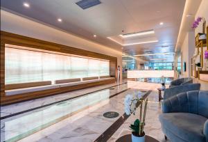 a swimming pool in a lobby with blue chairs at Apartments Black Sea Resort in Batumi