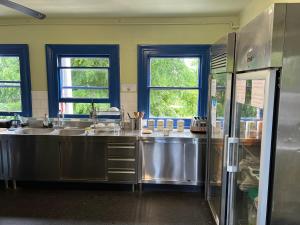 eine Küche mit Küchengeräten und Fenstern aus Edelstahl in der Unterkunft Hootananny Hostel in London
