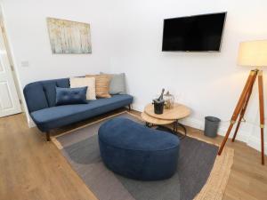 a living room with a blue couch and a table at The Look Out in South Shields