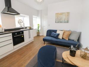 een woonkamer met een blauwe bank en een tafel bij The Look Out in South Shields