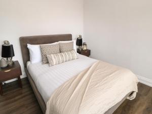 een slaapkamer met een bed met witte lakens en kussens bij The Look Out in South Shields