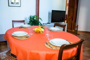 czerwony stół z talerzami i miskami owoców na nim w obiekcie Casa Rural Encarna w mieście Vega de San Mateo