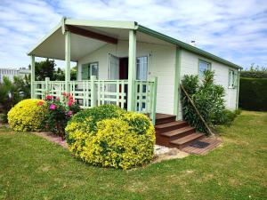 a small white house with a porch and a porch at Le Flamboyant - Piscines chauffees in Brem-sur-Mer