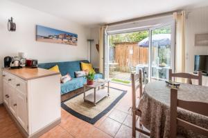 a living room with a blue couch and a table at Les Canonniers in Lège-Cap-Ferret +12 photos