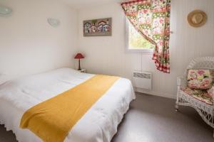 a bedroom with a bed and a window and a chair at Les Canonniers in Lège-Cap-Ferret