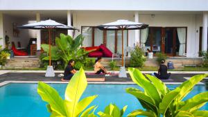 a group of people sitting in meditation by a pool at Tree Tops Mandalika in Kuta Lombok +2 photos