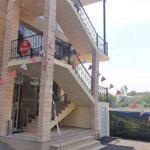 un edificio con una escalera con banderas. en Rahat Hostel, en Ganja