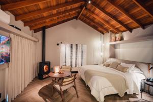a bedroom with a large bed and a table at Pousada Bella Terra in Gramado