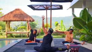 a group of people doing yoga by a pool at Tree Tops Mandalika in Kuta Lombok