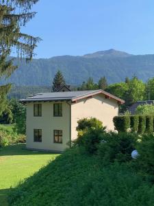 une maison sur une colline avec une cour verdoyante dans l'établissement Pension & Apartments Waldkrieber, à Presseggersee