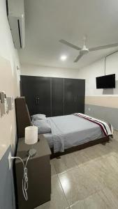 1 dormitorio con 1 cama y 1 mesa con lámpara en Departamento Orellana 11 en Chetumal