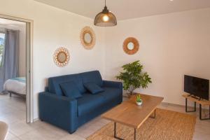 een blauwe bank in een woonkamer met een tafel bij apart Levante shared swimming pool bbq in Calenzana