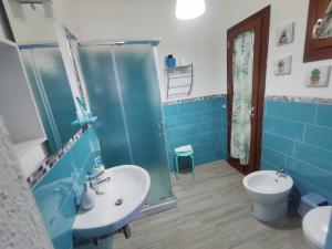 bagno blu con lavandino e servizi igienici di Sisinedda a Siniscola