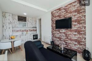 a living room with a couch and a brick wall at Apartment Sunset in Kotor +21 photos