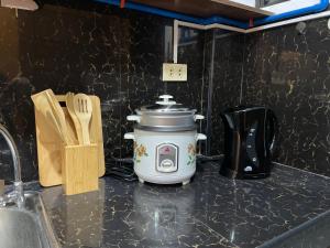 a slow cooker sitting on top of a kitchen counter at Sto. Niño Residences Standard Room in Lucena