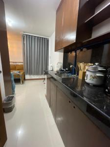 uma cozinha com um lavatório e uma bancada em Sto. Niño Residences Standard Room em Lucena