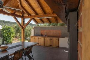 a kitchen with a table and chairs and a counter at Apartman Sorelle in Kali