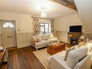 a living room with a couch and a fireplace at Oma's Cottage in Moreton in Marsh