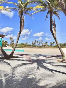 dwie palmy na plaży z basenem w obiekcie Pink Paradise at Seascape. Getaway by the beach! w mieście Riviera Beach