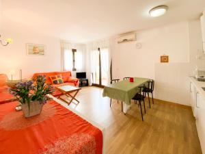 a living room with an orange couch and a table at Apartment Nerea in L'Escala
