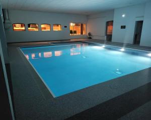a large swimming pool in a building with at Hôtel Causse Comtal Rodez, The Originals Relais in Gages-le-Haut