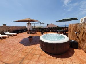 wanna z hydromasażem na patio ze stołami i parasolami w obiekcie Rico Apartaments Ricosol w mieście Torrox Costa