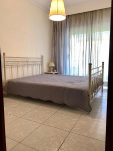 sypialnia z łóżkiem i dużym oknem w obiekcie Uranias Beach House w mieście Kalivia Poligirou