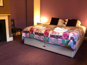 Pewsey的住宿－Circles Guest House，一间卧室配有一张大床和色彩缤纷的毯子