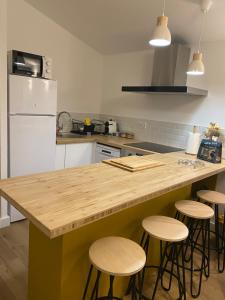 a kitchen with a wooden counter top and stools at Mont gozzi in Ajaccio