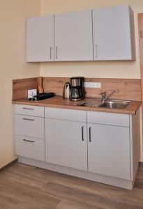 a kitchen with white cabinets and a sink at Wohnung "Wolgast" in Gützkow