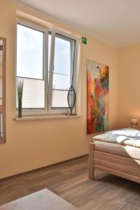 a bedroom with a bed and two windows at Wohnung "Wolgast" in Gützkow