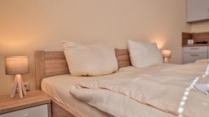 1 dormitorio con 1 cama con sábanas y almohadas blancas en Wohnung "Wolgast", en Gützkow