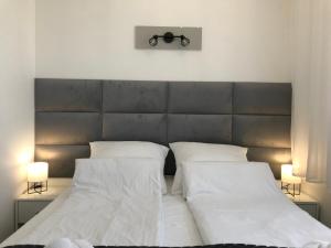 1 Schlafzimmer mit 2 Betten mit weißer Bettwäsche und 2 Lampen in der Unterkunft Apartament 215 Planeta 2-pokojowy z balkonem in Mielno