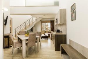 a kitchen and dining room with a table and chairs at Aria Garden Suites in Nikiti