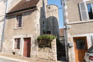 an old building with a clock tower on a street at Appartement Meneau in La Charité-sur-Loire