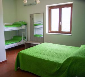 La Casa sulla Collina في Altavilla Silentina: غرفة خضراء مع سريرين بطابقين ونافذة