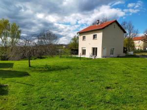 a white house with a red roof on a green field at Maison De La Fontaine Verte Proche Albi- Rodez- Carmaux in Carmaux