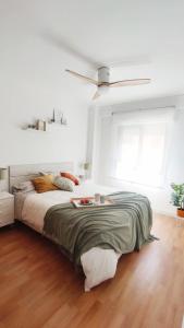 - une chambre blanche avec un grand lit et un ventilateur dans l'établissement Casa Yaye, à Fuengirola