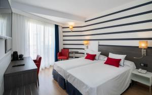 a hotel room with a large bed with red pillows at Medplaya Hotel Riudor - Adults Recommended in Benidorm