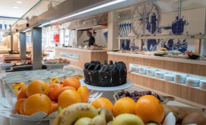 a buffet line with fruits and cakes on plates at Medplaya Hotel Riudor - Adults Recommended in Benidorm